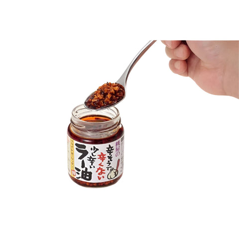 Japansk chiliolie med stegt hvidløg på en ske – den smukke røde chiliolie med sprøde hvidløgsstykker fremhæver den fyldige umami, den aromatiske duft og den autentiske japanske smag.