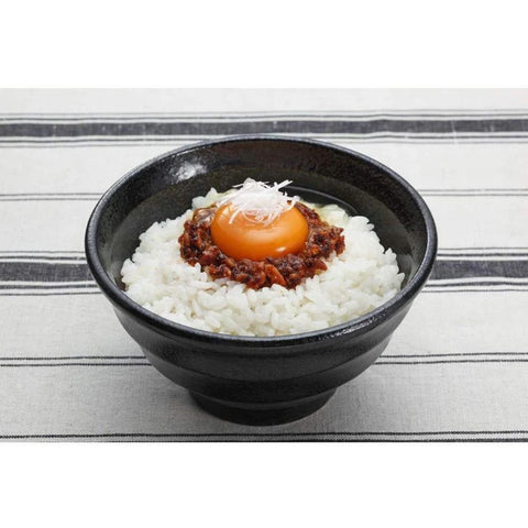 Skål med dampende ris, cremet æggeblomme og japansk chiliolie med stegt hvidløg – en autentisk japansk servering, hvor den aromatiske chiliolie tilfører fyldig umami, sprødhed og behagelig varme.