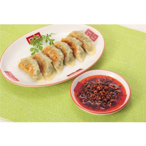 Sprøde japanske dumplings serveret med chiliolie med stegt hvidløg som dip – autentisk japansk smagsoplevelse med fyldig umami, sprøde hvidløgsstykker og en velafbalanceret styrke.