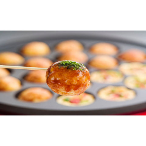 Takoyaki i en traditionel japansk takoyaki-pande – de små kugler formes og steges i den specielle pande, som giver den karakteristiske sprøde overflade og bløde, saftige midte.