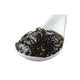 Tsukudani med wakame og nori tang på en japansk ske – den smukke, blanke tangdelikatesse med dyb mørkegrøn farve og intens umami. Den traditionelle japanske tsukudani er langsomt simret i sojasauce og mirin og er perfekt som topping til ris, sushi, onigiri, tofu og andre autentiske japanske retter.